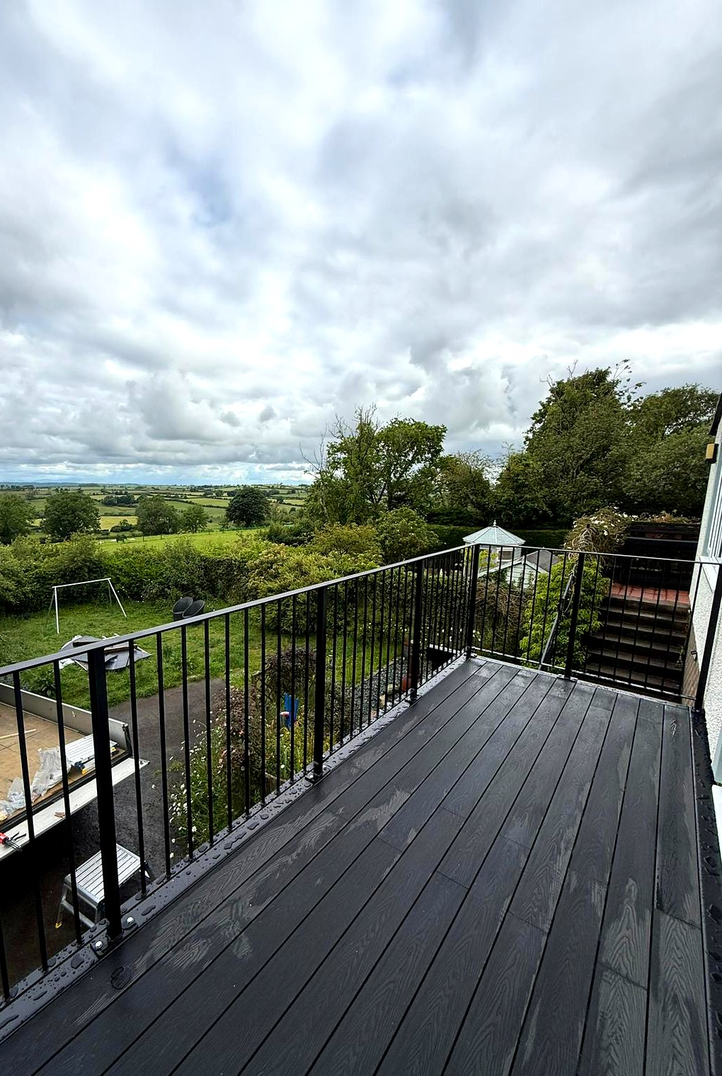 View over Cumbrian countryside from a walkout balcony with black composite decking and metal railings